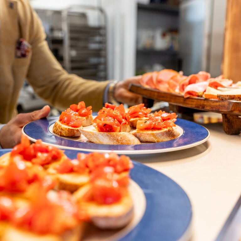 Una serie di immagini che mostrano l'interno e l'esterno del Doga Ristorante alla Marina di Scarlino, tra cui la sala da pranzo, il dehors, il bar, la cucina e alcuni piatti della cucina toscana.